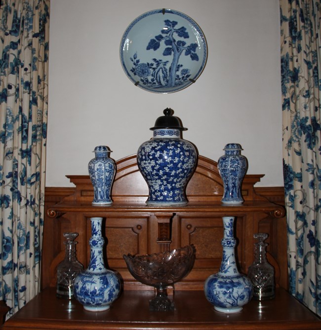 A display of blue-and-white vases and jars with a large charger above, in the Mansion's dining room.