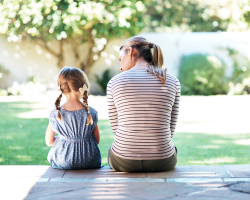 mother and daughter sitting on a porch
