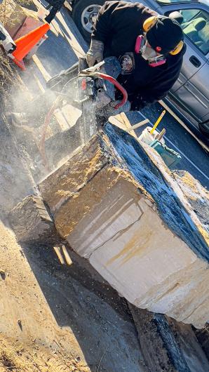 Walter Torres uses a high-powered wet saw to sculpt a slab of stone.