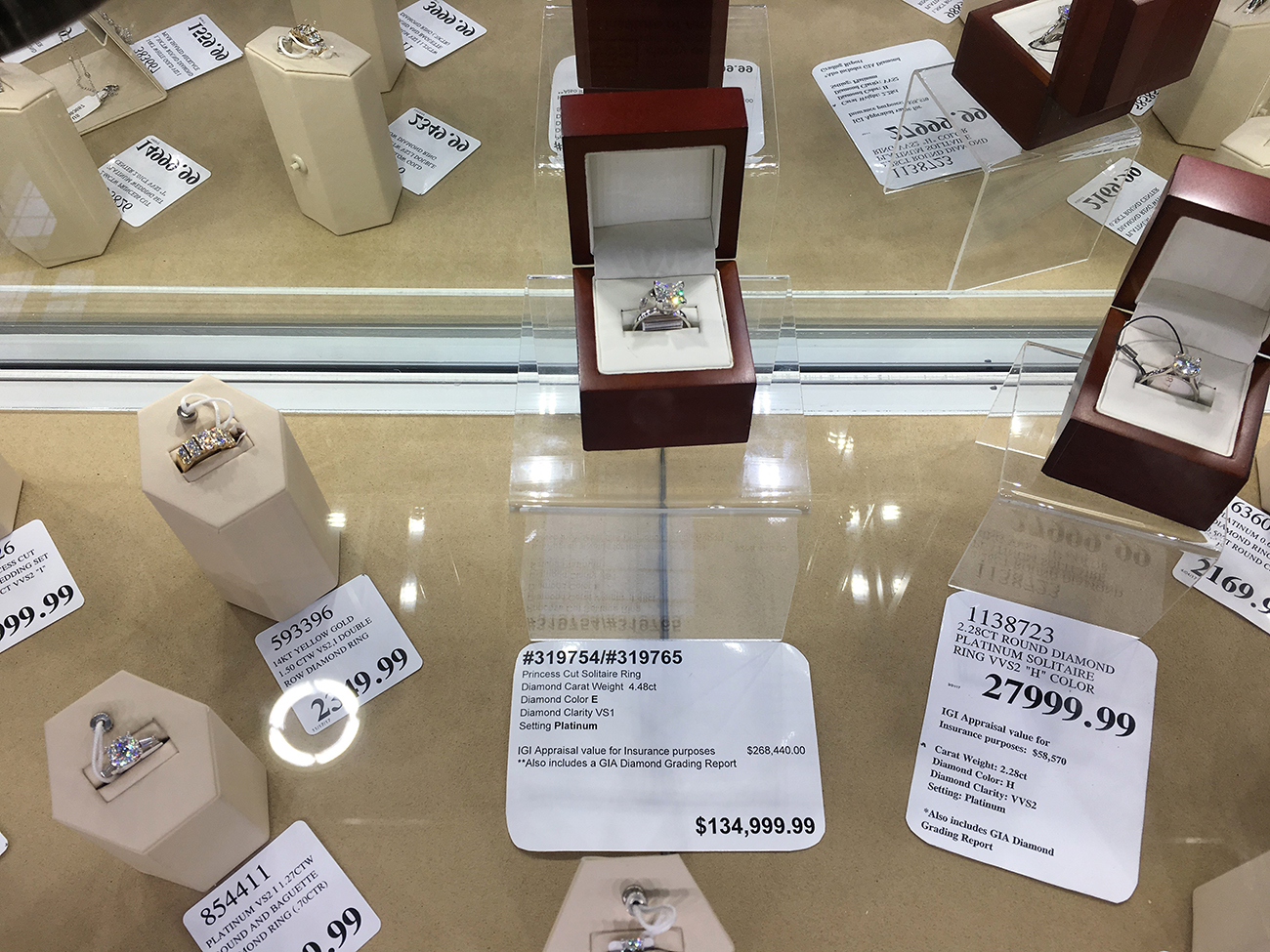 A photograph shows a jewelry display case filled with diamond rings. Some of the rings cost upward of 130,000 dollars.