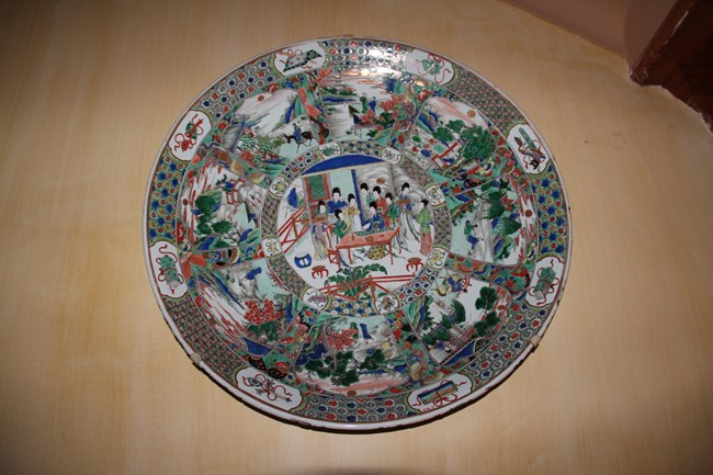 A Famille Verte charger hanging on the wall of the staircase.