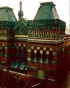 Red brick building with two wide towers trimmed in marble.