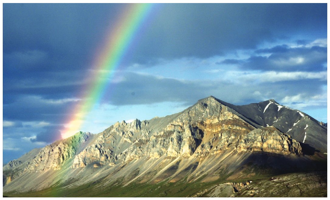 Overturned sedimentary rocks of the Lisburne Group under a midnight rainbow near Galbraith Lake, Alaska, summer 2001. USGS photo by David Houseknecht.