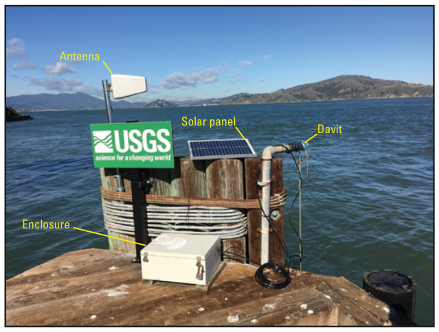 A monitoring station on a piling at Alcatraz Island, with an antenna, solar panel, davit and equipment enclosure