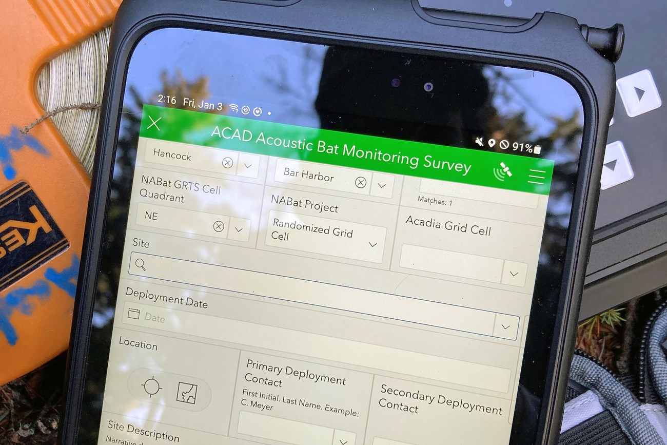 A tablet on a pile of field gear showing a data-entry form