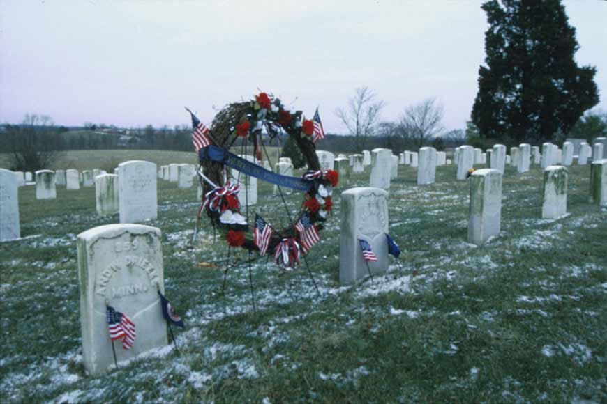A wreath with flags among white headstones at Mill Springs National Cemetery.