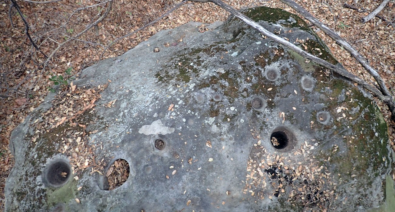 Deep round holes worn into a rock surface
