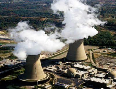 Two cooling towers releasing steam at a power plant
