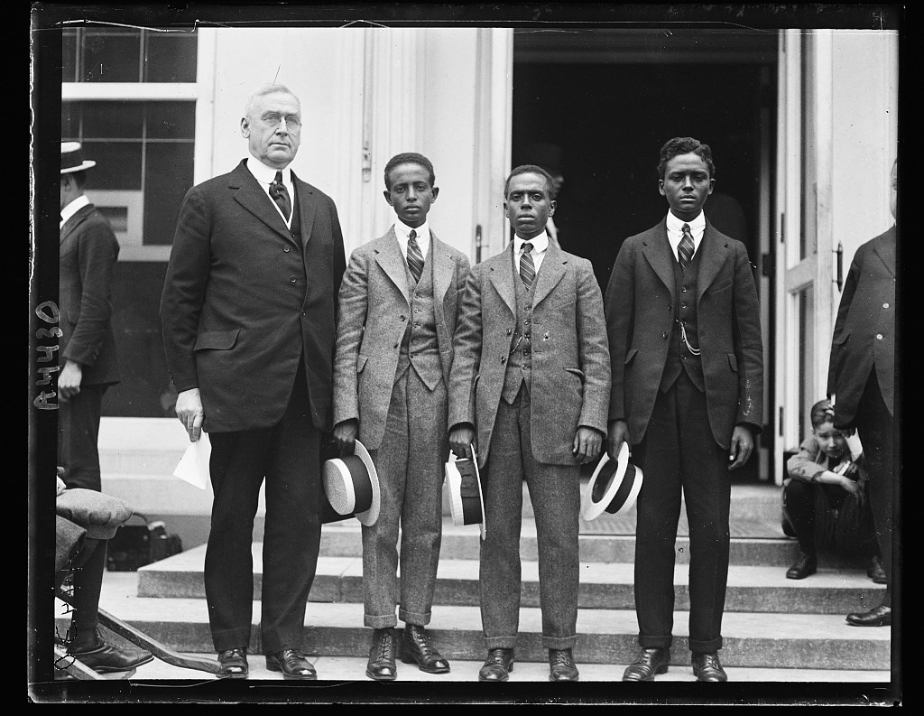 A white man and three African American men standing on the steps of the White House.