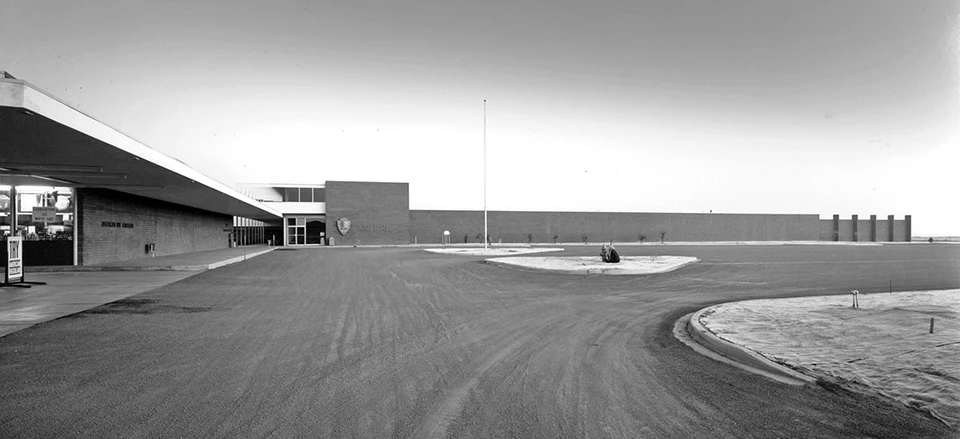 Painted Desert Community Complex is a low, ell-shaped modern style building frames a large parking lot, with several planting islands.