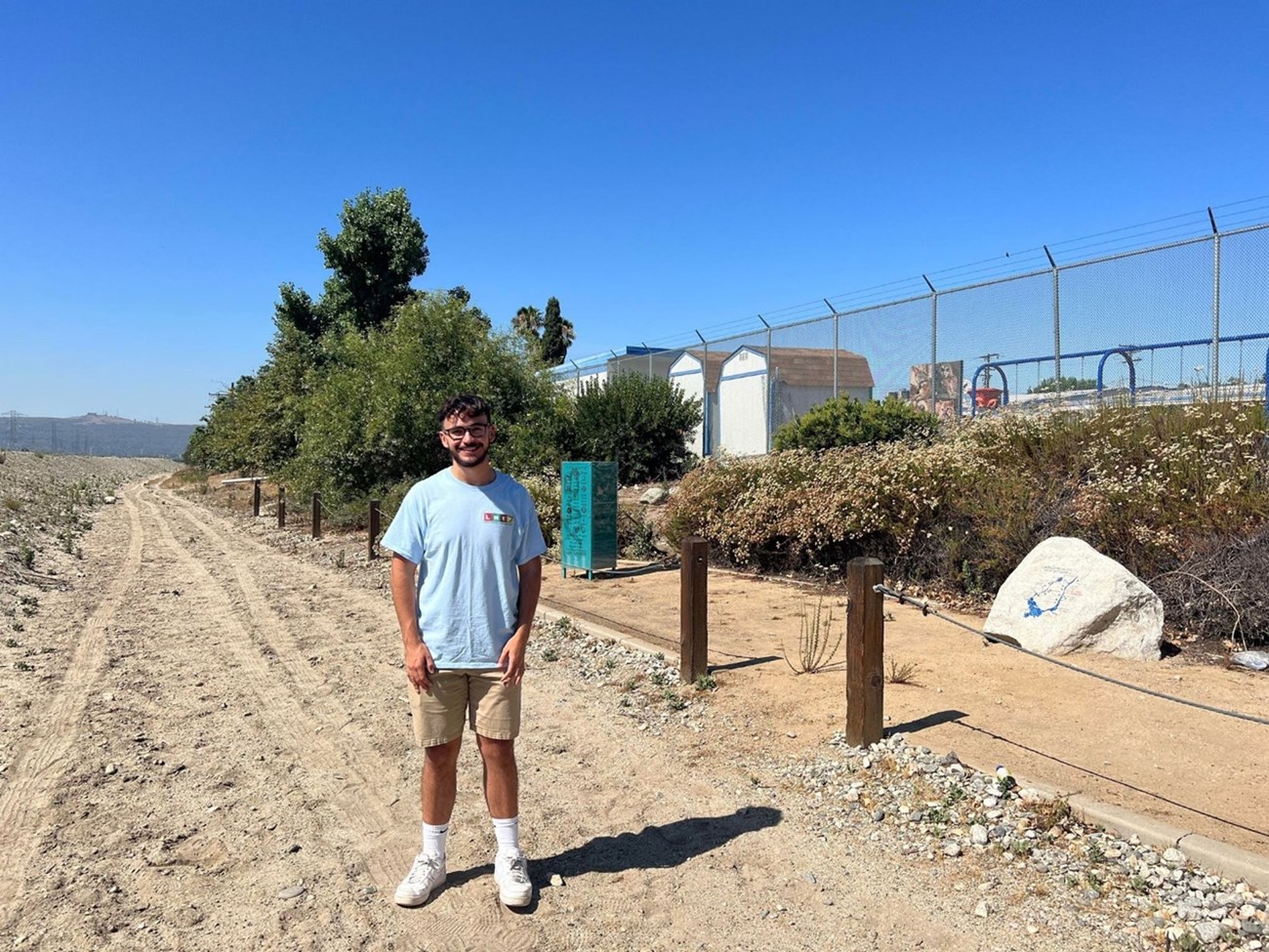 An intern stands at the La Primaria site along the San Gabriel River Trail
