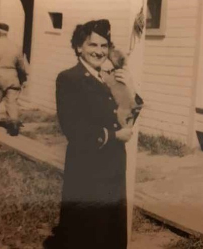 Sepia photo of a woman in dark uniform holding a small dog