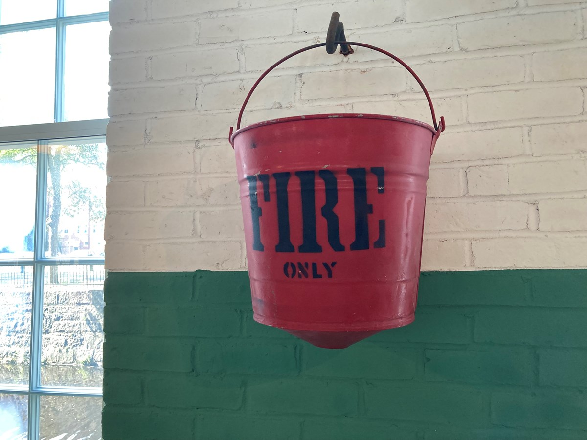 A fire bucket hanging in a mill weave room.