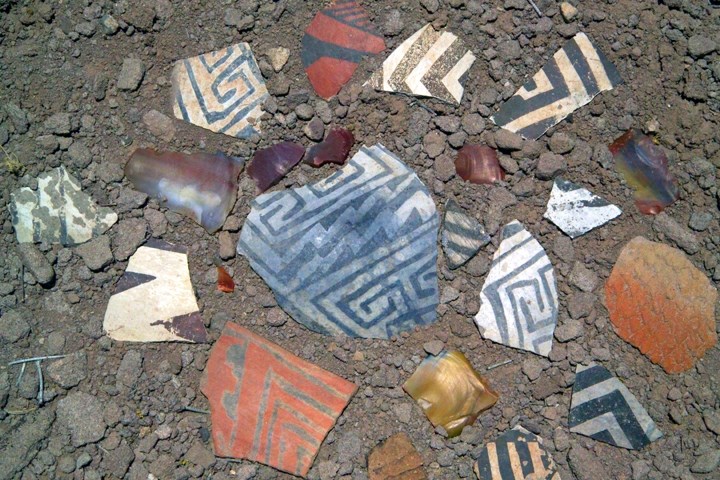 Colorful patterned pottery shards on the ground.