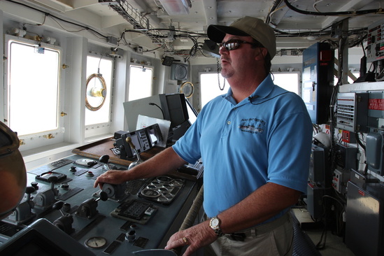 The commanding officer at the helm on the bridge