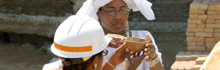 An archeologist in a hard hat examining a find