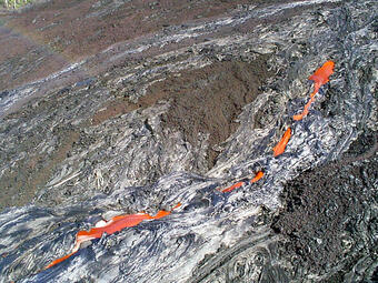 A glowing channel of lava running down a slope