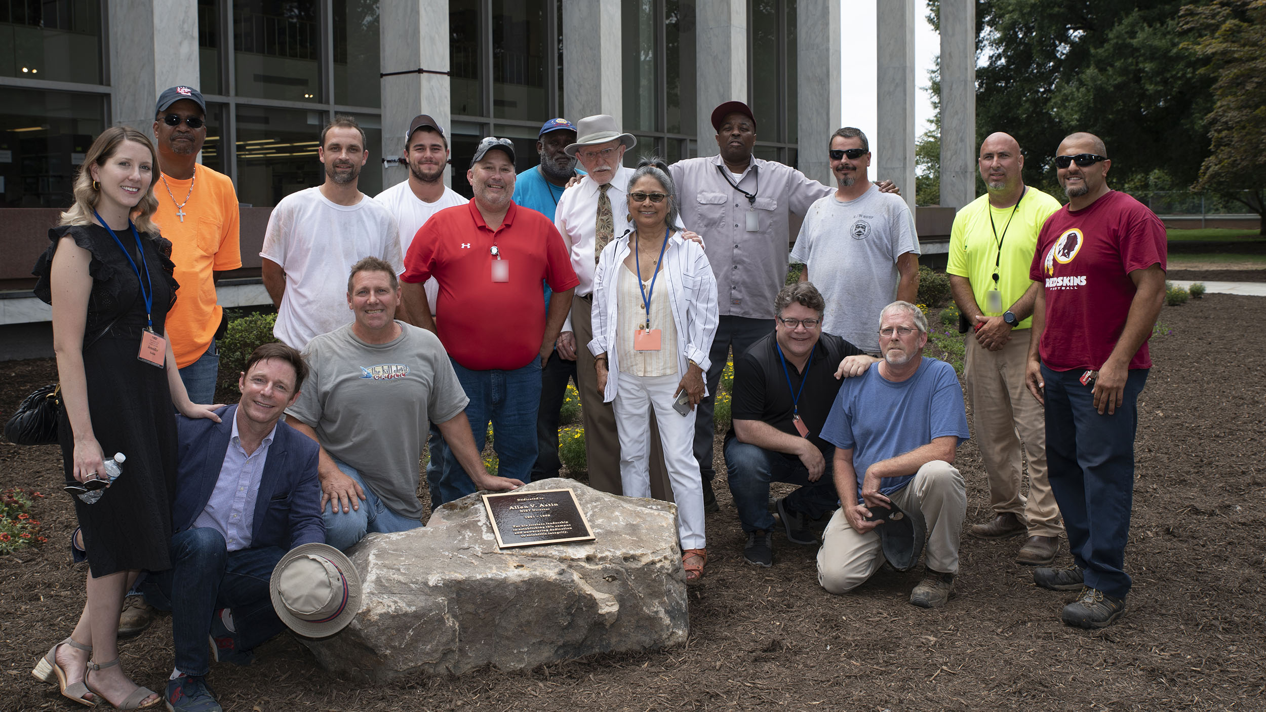 A large group posed outdoors in a garden