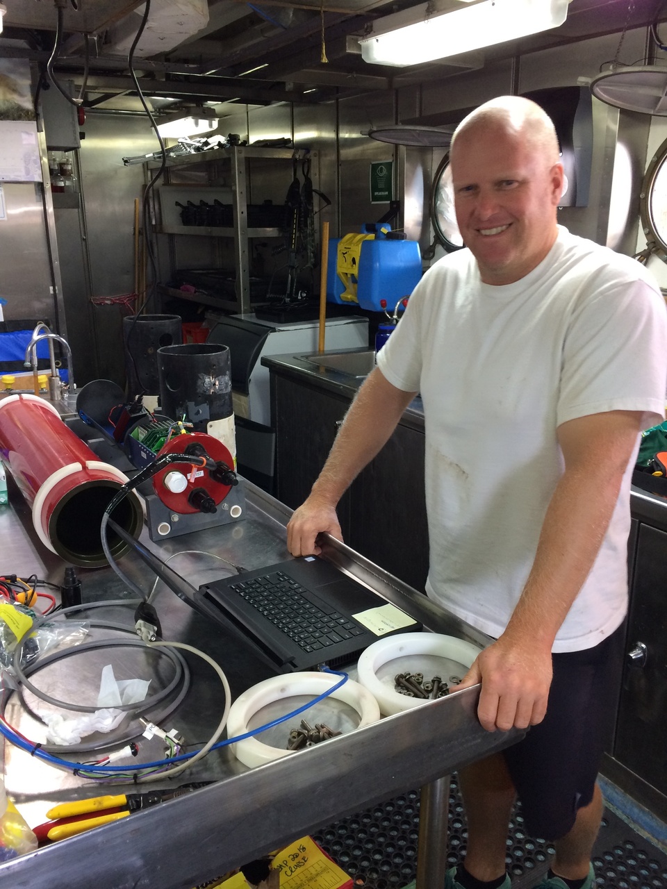 A scientist refurbishes a seafloor recording package on deck