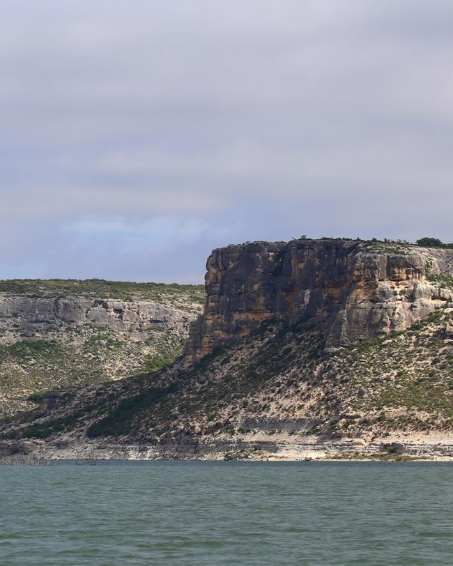A lake below limestone bluffs.