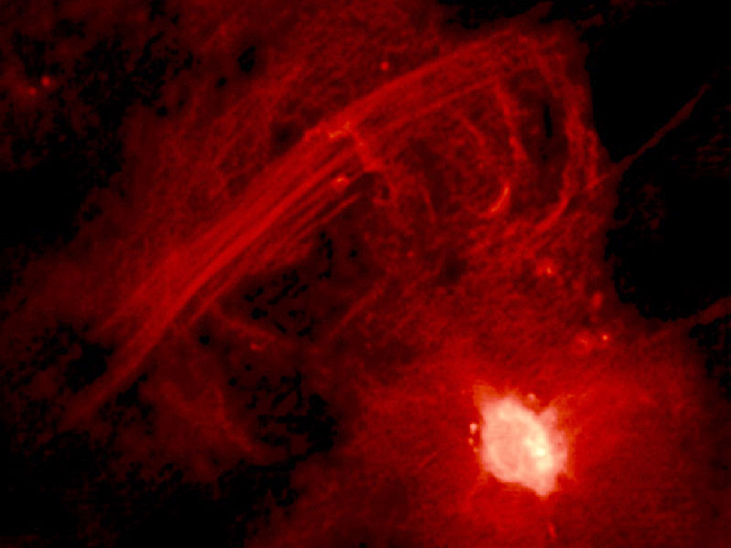 Central 10 Light-Years of the Galaxy. The bright region at lower right is Sagittarius A* and the straight filaments running from lower left to upper right are collectively known as “The Arc”. See Figure 25_04_RImage to see these features in context with other objects near the galactic center.
