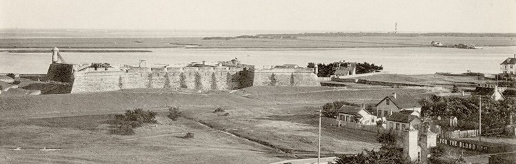 A historic photograph of the Castillo de San Marcos on the waterfront