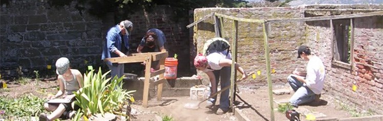 Archeologists excavating inside a walled area