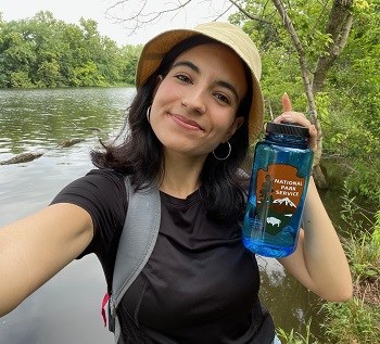 Nicole Segnini smiling in a park, holding an NPS water bottle