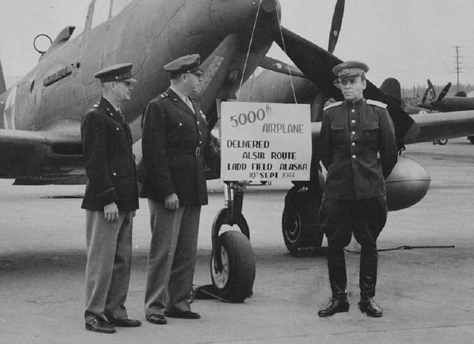 Servicemen in front of an aircraft with a sign reading "5000 airplane"