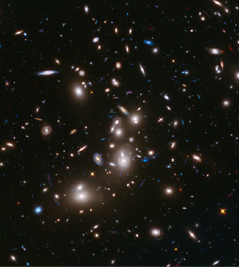 Image of galaxy cluster Abell 2744. Several large, bright elliptical galaxies dominate this cluster of galaxies, which is massive enough to act as a gravitational lens to brighten and magnify the images of nearly 3000 distant background galaxies.