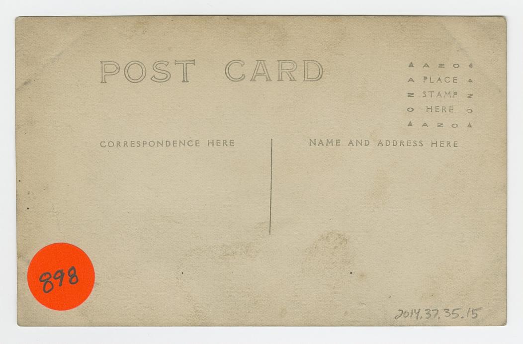 Postcard of two men posing in a Western scene in a photography studio