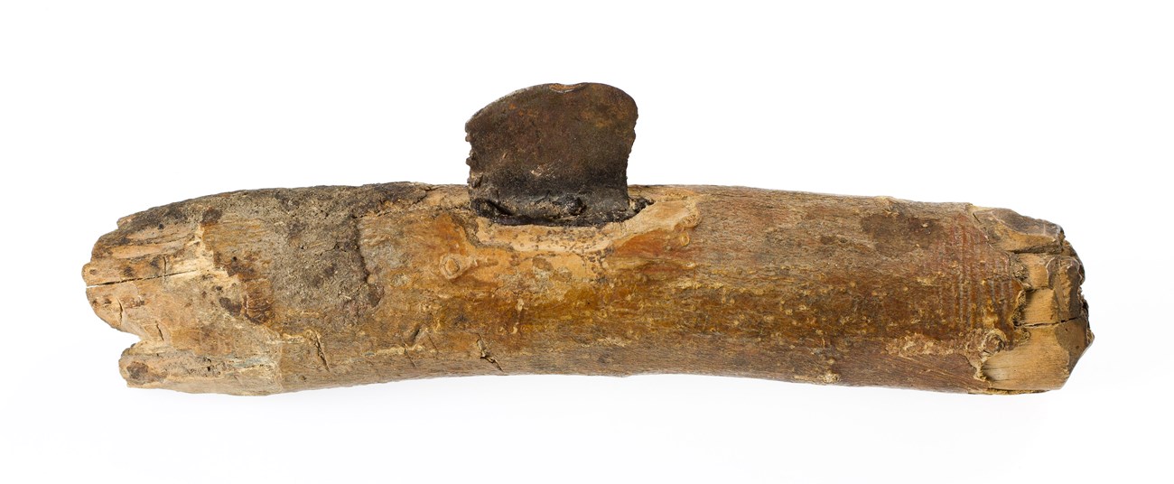 A stone blade set into the middle of a wooden handle.